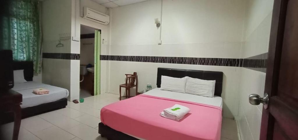 Un dormitorio con una cama rosa y un baño. en E657 SERi TERUNTUM, en Kuantan