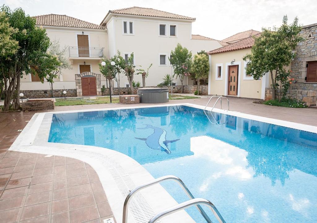 a swimming pool with a dolphin stencil on the side of a house at Erietta Studios & Apartments by Kika Residences in Stoupa