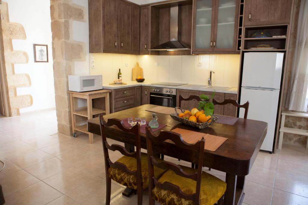 a kitchen with a table with a bowl of fruit on it at Cretan cottage of 1900 with beautiful olive yard in Kissamos
