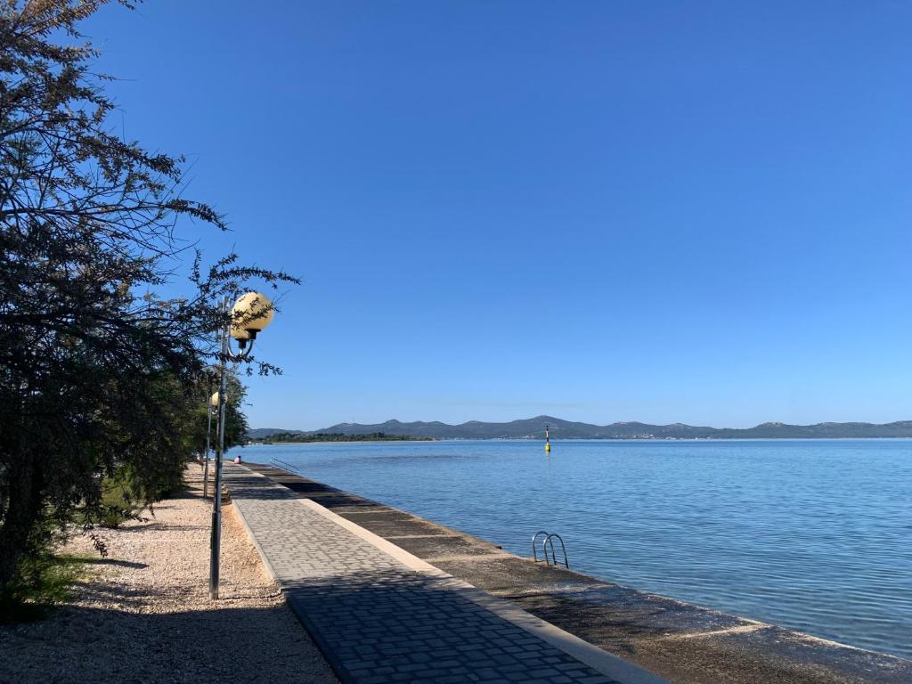 a walkway next to a body of water at Room with Balcony and Sea View in Zadar