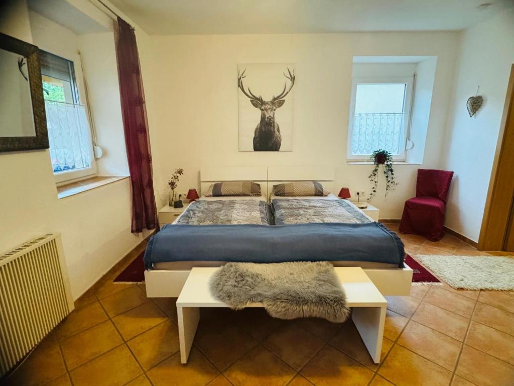 a bedroom with a bed and a deer head on the wall at Forest Nest Huchenfeld in Pforzheim