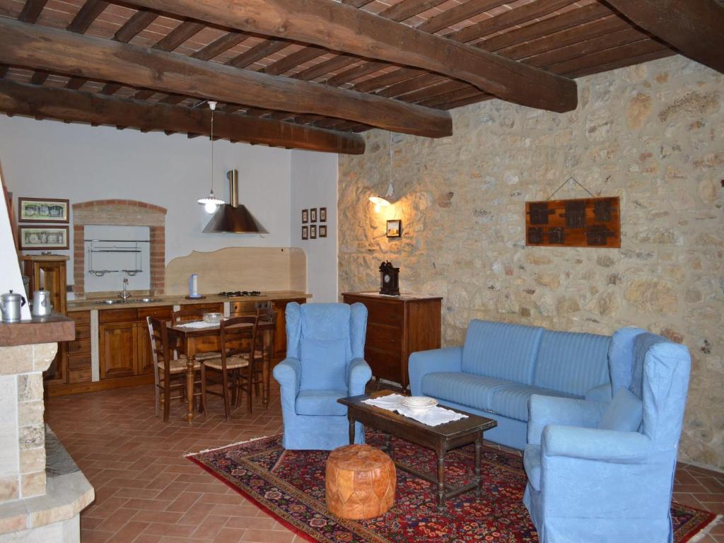 a living room with a blue couch and a table at Tuscan Retreat in Montalceto in Serre di Rapolano