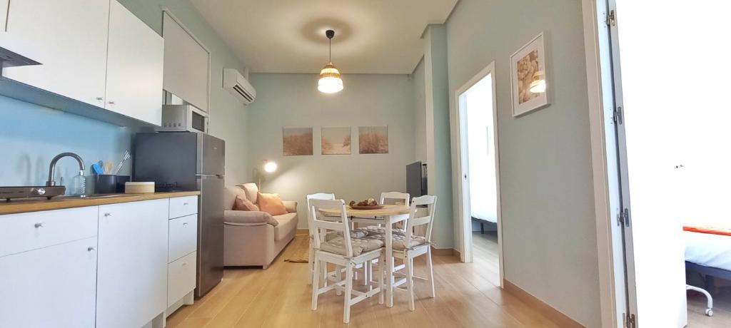 a kitchen and living room with a table and chairs at Guadalimar in Seville
