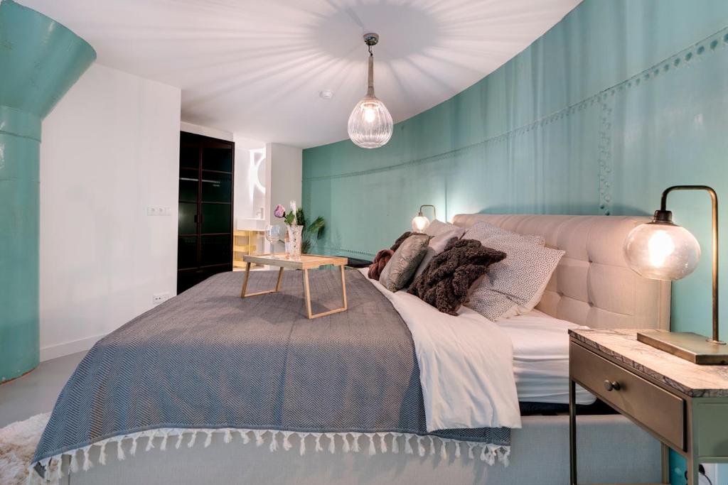 Un dormitorio con una cama y una pared azul. en Hotel Watertoren West, en Groninga