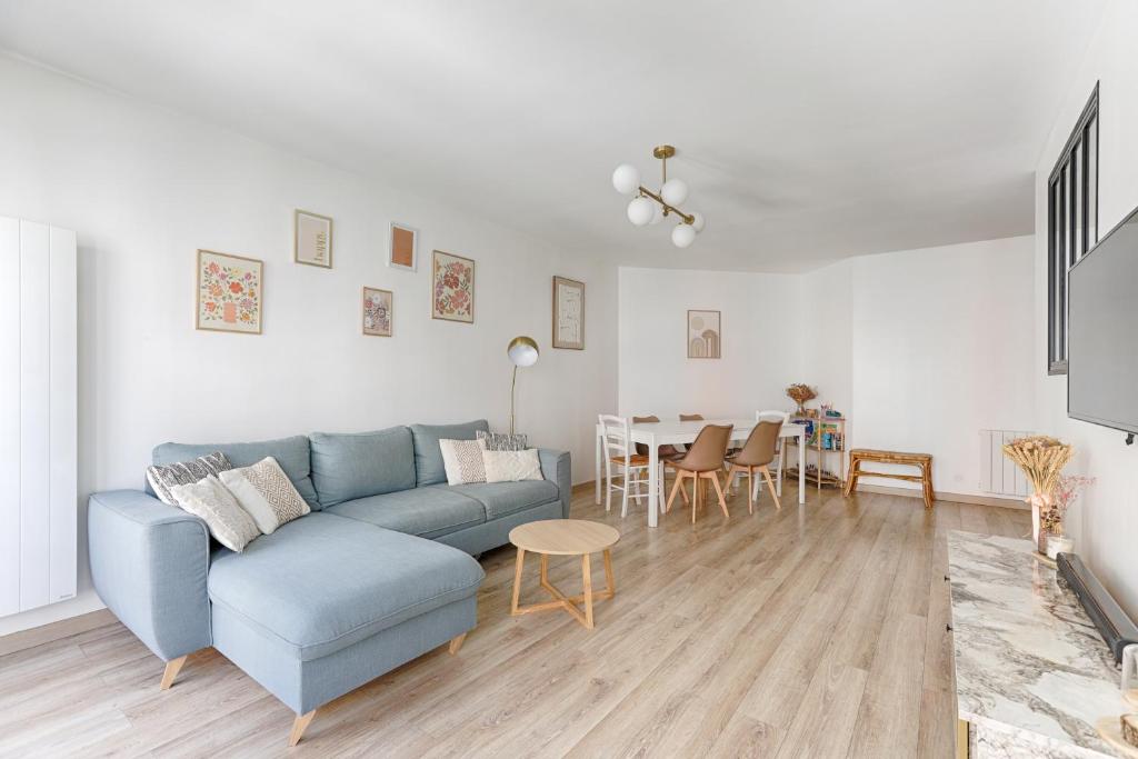 a living room with a blue couch and a table at Superbe appartement pour 6P aux portes de Paris in Saint-Maurice
