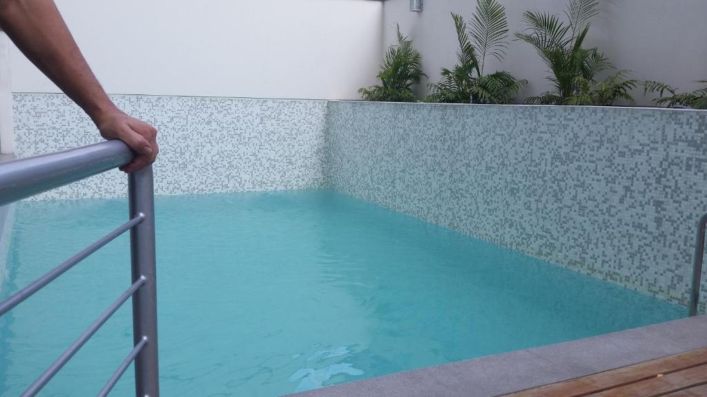 una persona apoyada en una barandilla cerca de una piscina en Temporal Apartment, en Lima