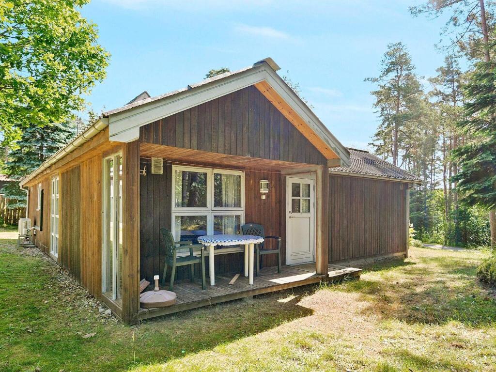 Una pequeña cabaña con un porche y una mesa de picnic. en 7 person holiday home in Kolind-By Traum, en Kolind