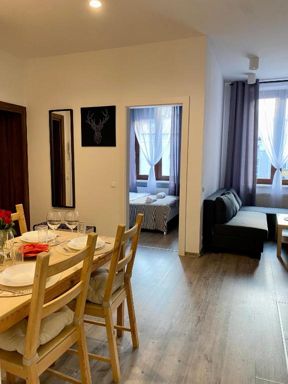 a dining room with a table and a living room at Loftson Apartament in Konin