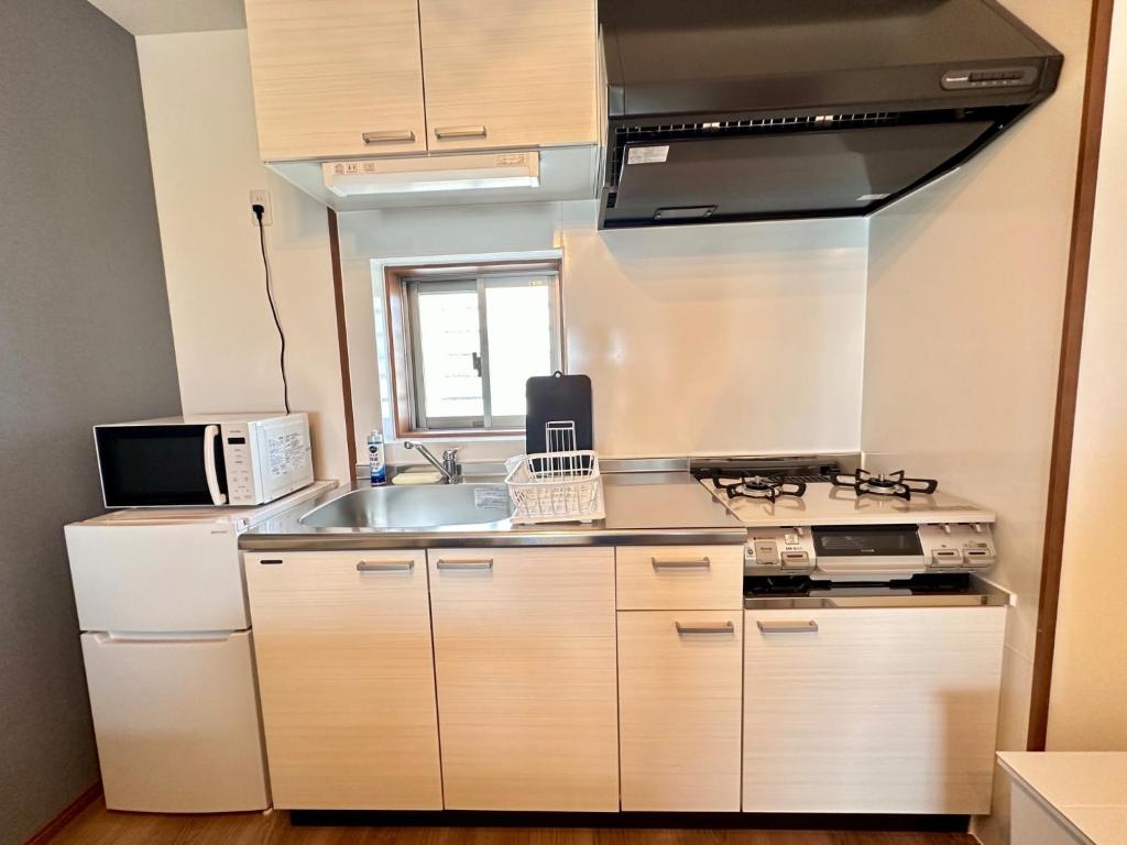 a kitchen with a sink and a stove top oven at Kin-Con-Kan - Vacation STAY 05378v in Nanjo