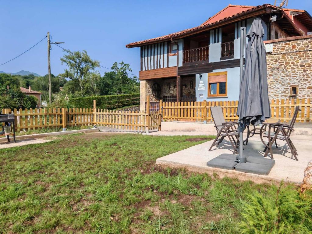 a patio with an umbrella and chairs in front of a house at Casa Verana en Asturias VV-3421-AS in Granda