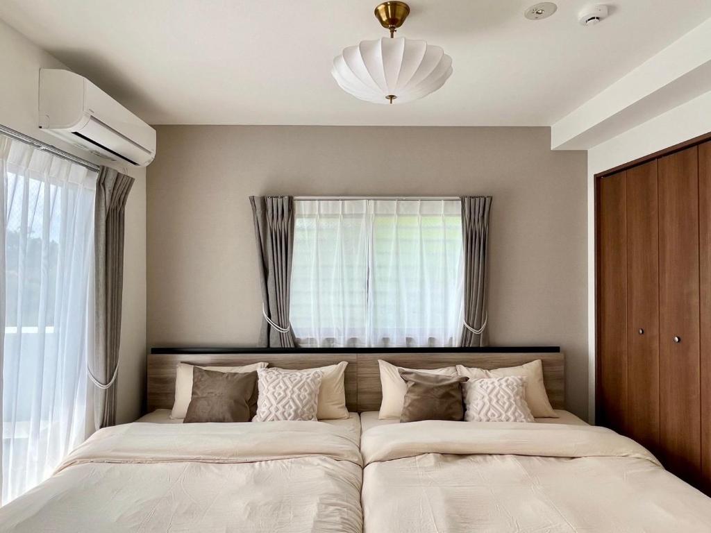 a bedroom with two beds in front of a window at Kin-Con-Kan - Vacation STAY 05400v in Nanjo