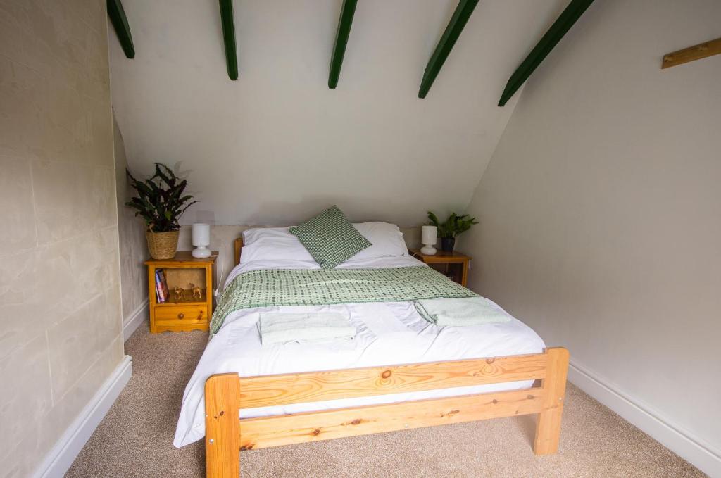 een slaapkamer met een bed met een houten bedframe bij Station Cottage in Bucknell
