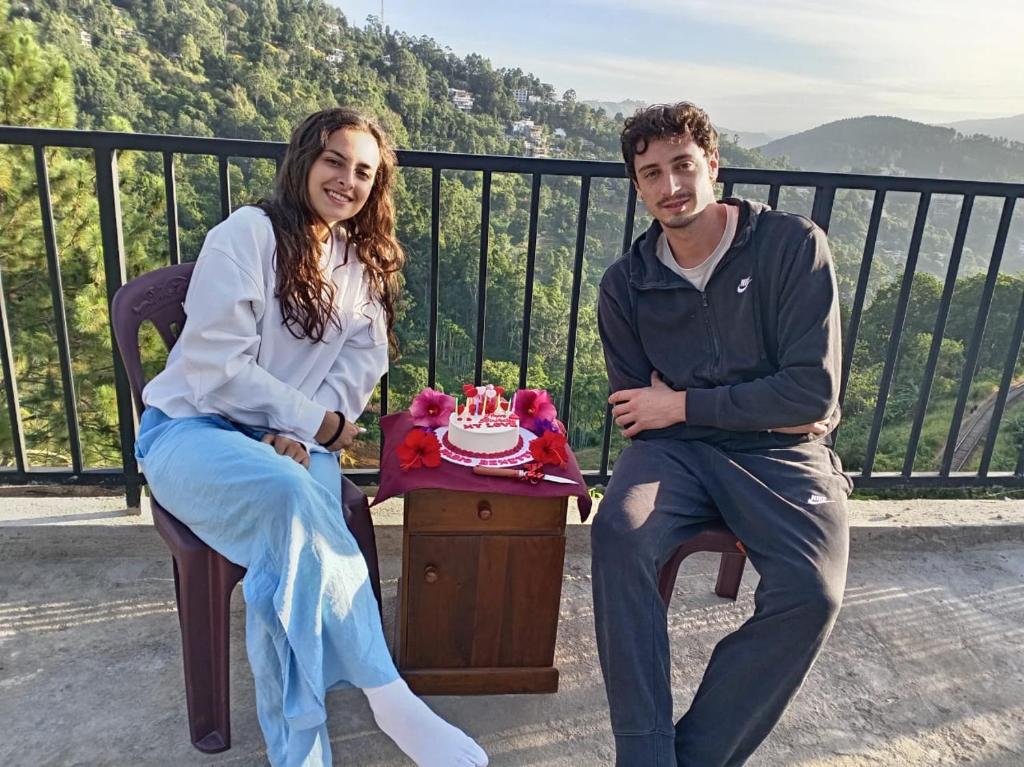 een man en een vrouw zitten op een bankje met een taart bij Lina Eco Cottage - Ella in Ella