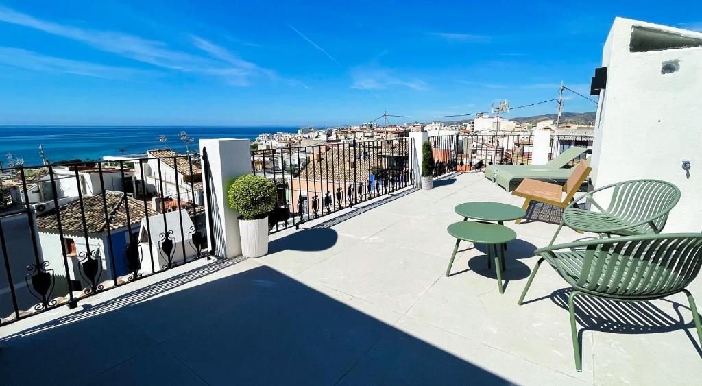 a balcony with chairs and tables and a view of the ocean at Heritage apartamentos in Villajoyosa