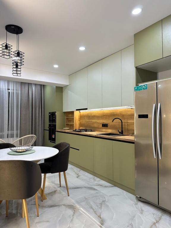 a kitchen with a table and a stainless steel refrigerator at Artima Downtown in Chişinău