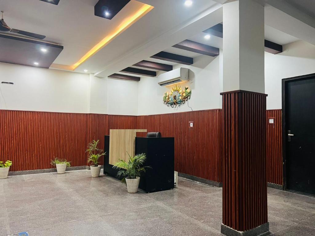 Un vestíbulo con paredes rojas y plantas en macetas. en HL Residency Near Expo Mart Centre, en Greater Noida