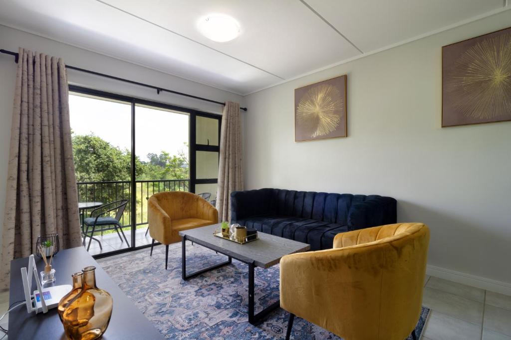 a living room with a couch and a table at #AlimamaSpaces Jade's Greenlee in Sandton