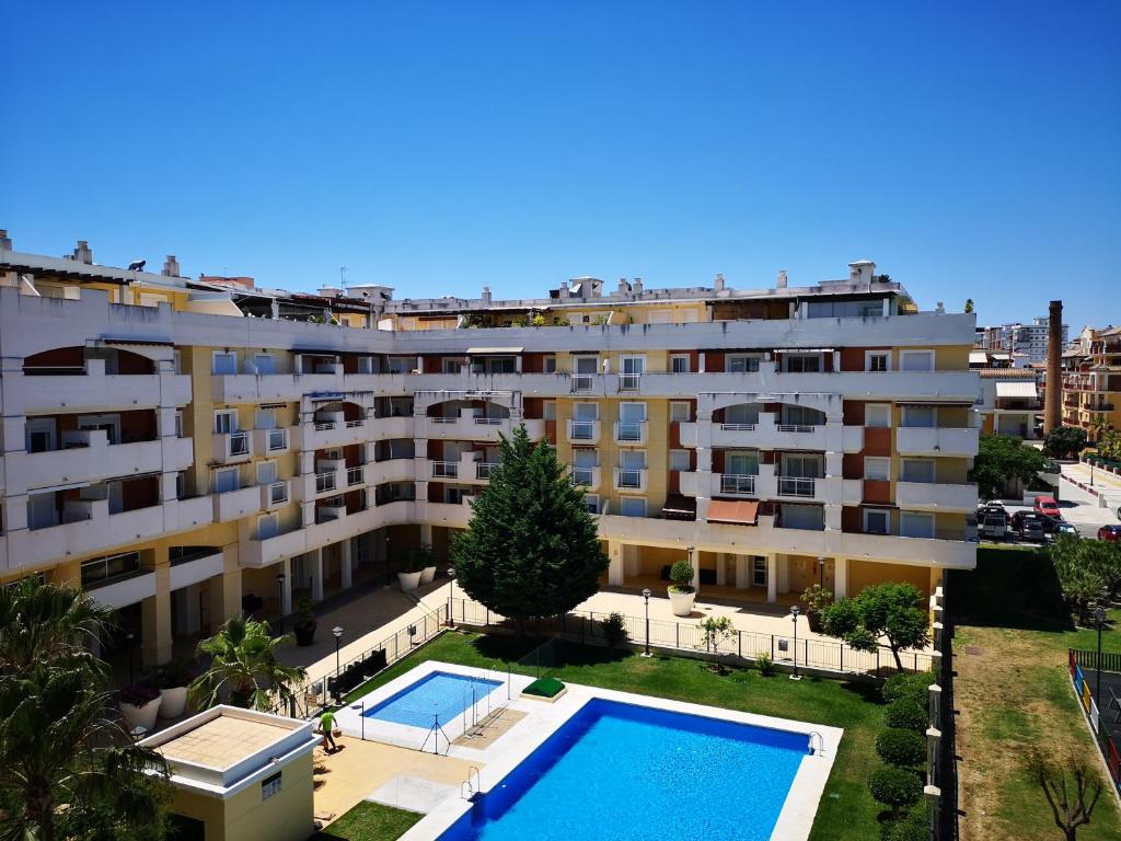 an apartment with a swimming pool in front of a building at Terrasol Torrelitoral 1 dormitorio in Torre del Mar