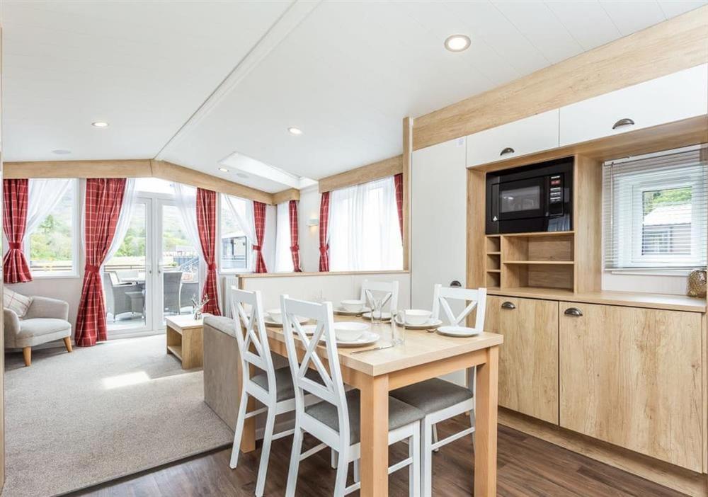 Una cocina y un comedor con mesa y sillas. en Sanctuary 5 Hot tub lodge, en Fort Augustus