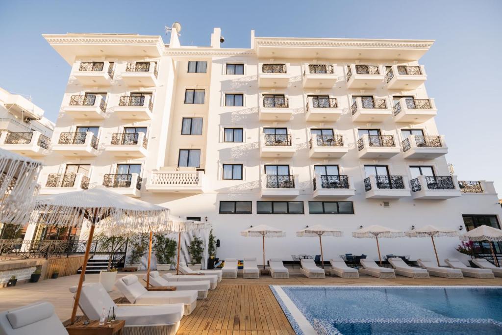 ein Hotel mit einem Schwimmbad vor einem Gebäude in der Unterkunft Chimaera Hotel in Himarë