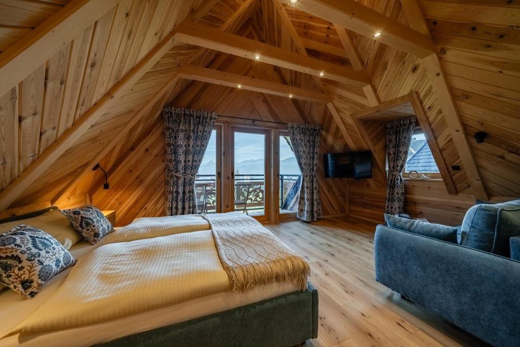 a bedroom with a bed and a couch in a room at Apartamenty Tatra Loft in Ząb