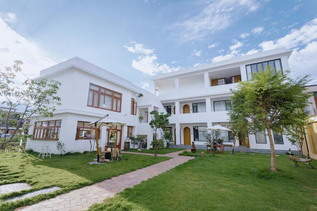 un gran edificio blanco con un patio de césped en SIDDHI INN, en Dali