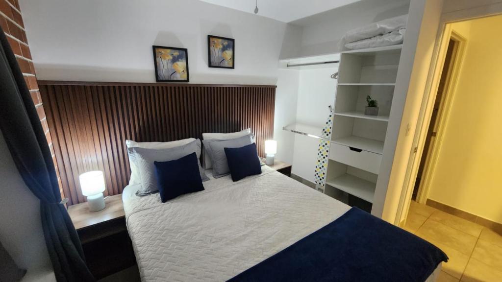um quarto com uma cama com duas almofadas azuis em 5CERO2 STAYMENTS - Hermoso y Cómodo Apartamento Tipo penthouse em Guatemala