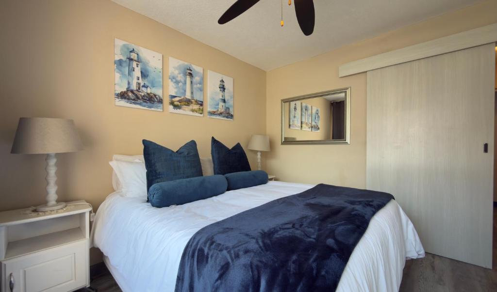 a bedroom with a large bed with blue pillows at Stylish stay at Hartensee in Mossel Bay