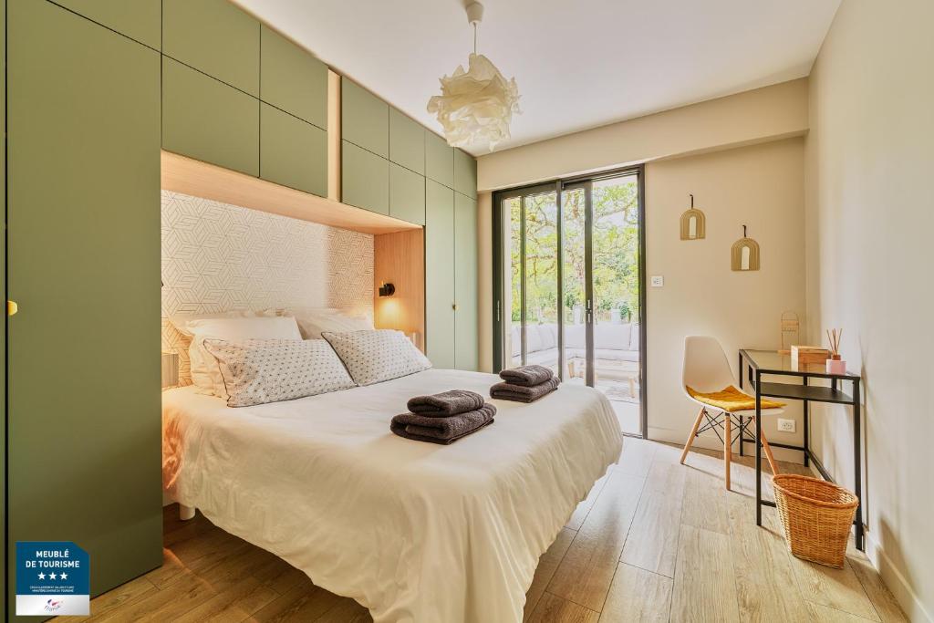una camera da letto con un letto grande con asciugamani sopra di Détente, nature & océan en Bretagne - Le 154 a Pénestin