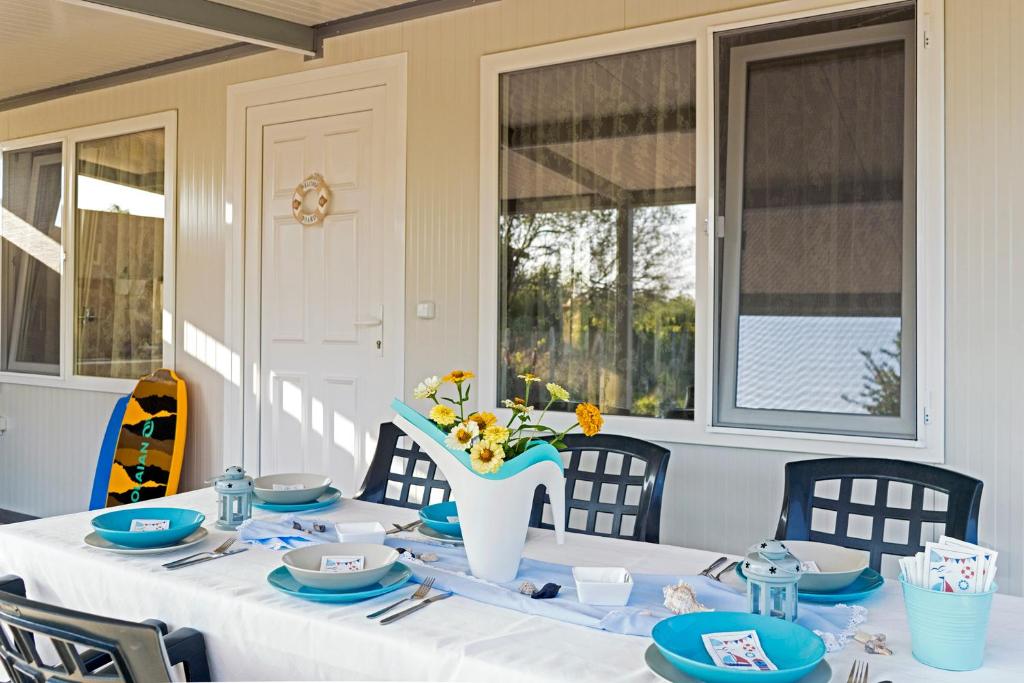 a table with a white table cloth and a vase of flowers at Family House GO TO - Parking & Dog Yard in Kavarna