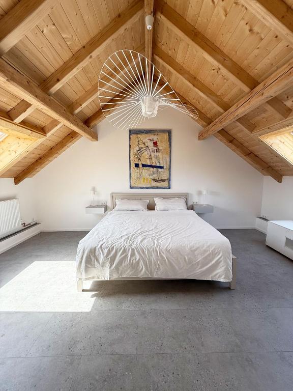 a bedroom with a large bed and wooden ceilings at Neues, stilvolles Loft inmitten der Weinberge 