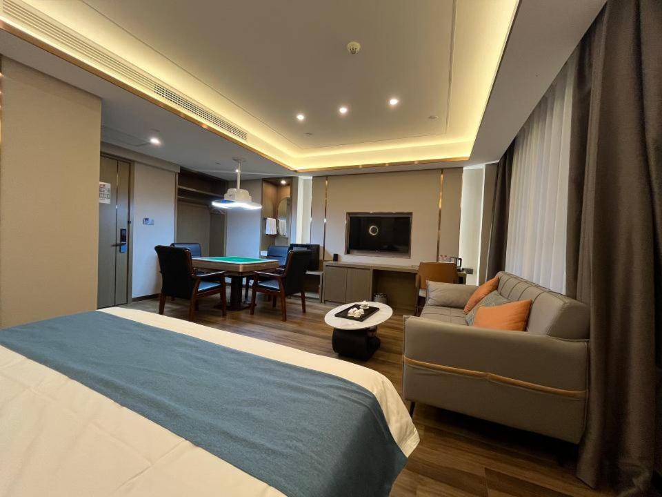 Una habitación de hotel con una cama y una sala de estar. en 万信至格酒店乌鲁木齐机场德港万达店, en Ürümqi
