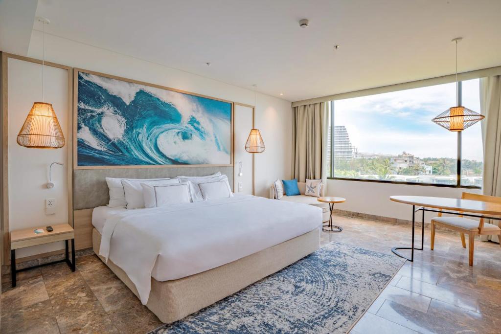 A king room with a wide picture window, a wave mural and a city-and-coast outlook.
