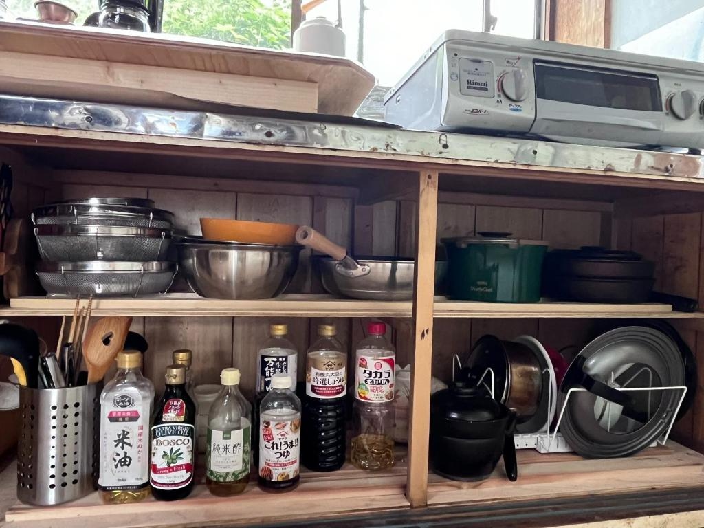a shelf with bottles and a microwave on it at Tonegun - House - Vacation STAY 17719 in Kawaba