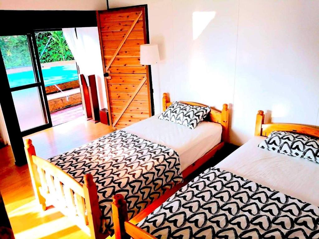 - une chambre avec 2 lits et une porte donnant sur un balcon dans l'établissement Birdland Nature Resort - Vacation STAY 76315v, à Akaoki