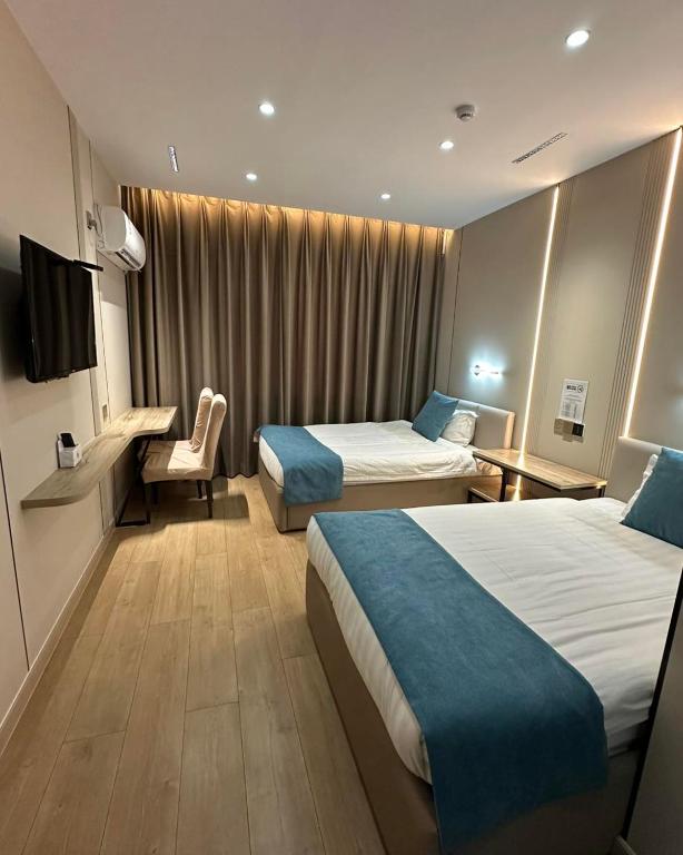 a hotel room with two beds and a television at Erkhes hotel in Dalandzadgad