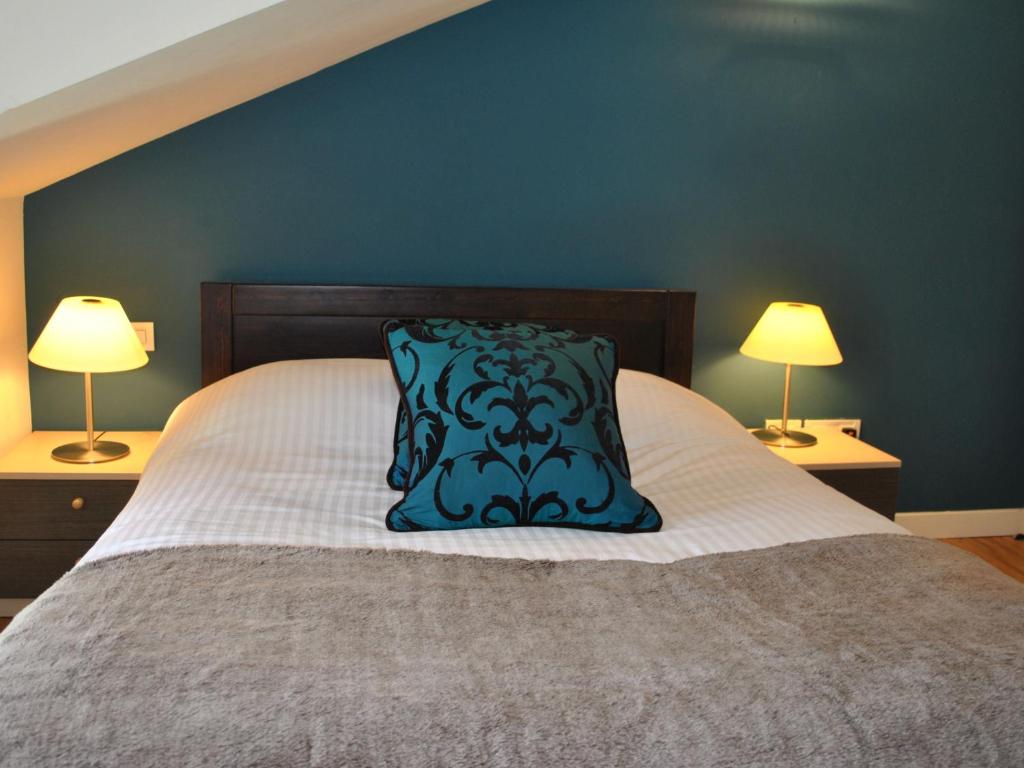 a bed with a blue pillow on it with two lamps at Dreamhouse Apartments Glasgow West End in Glasgow