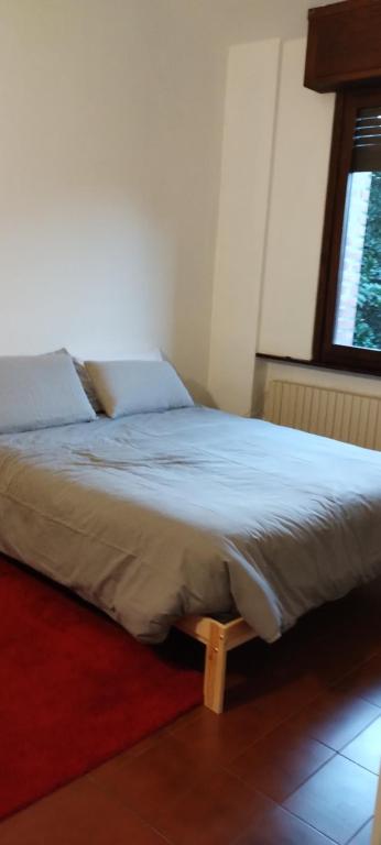a bed sitting in a room with a window at Villetta Cristina historic village Bellano-LC Comolake in Bellano