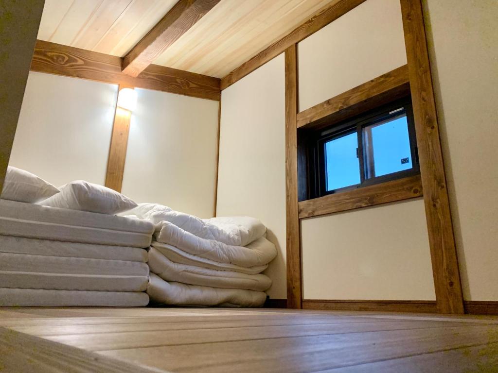 a room with a window and a pile of blankets at Ieka Village Kiyosasawa - Vacation STAY 33015v in Sadamitsu
