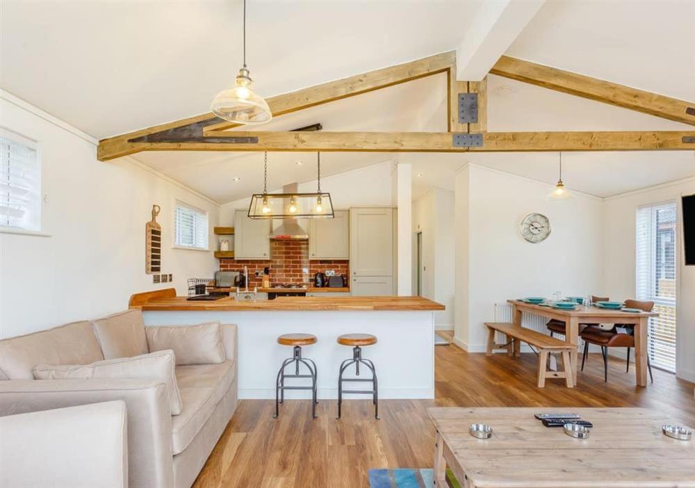 Sanctuary Caledonia Hot tub lodge في حصن أوغسطس: غرفة معيشة بها أريكة وطاولة