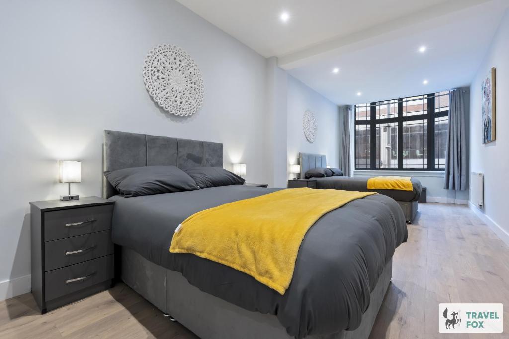 a bedroom with a large bed with a yellow blanket at Anna's Central Stay in Nottingham