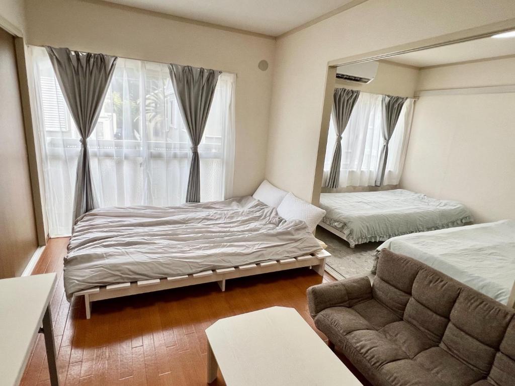 a bedroom with a bed and a couch and a mirror at Chigasaki JH Court C - Vacation STAY 17903 in Chigasaki