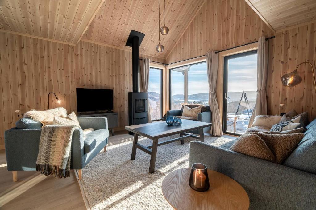 una sala de estar con un sofá y una mesa en Cabin at Norefjell ski resort, nice view, en Noresund