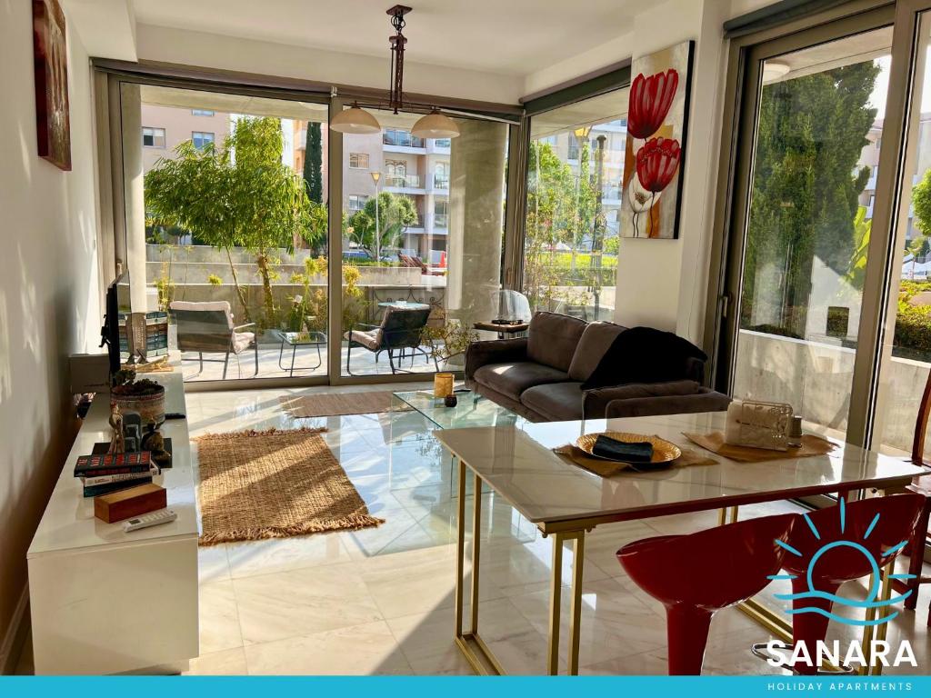 una sala de estar con un sofá y una mesa en Elysia Park Sanara Holiday Apartments, en Pafos