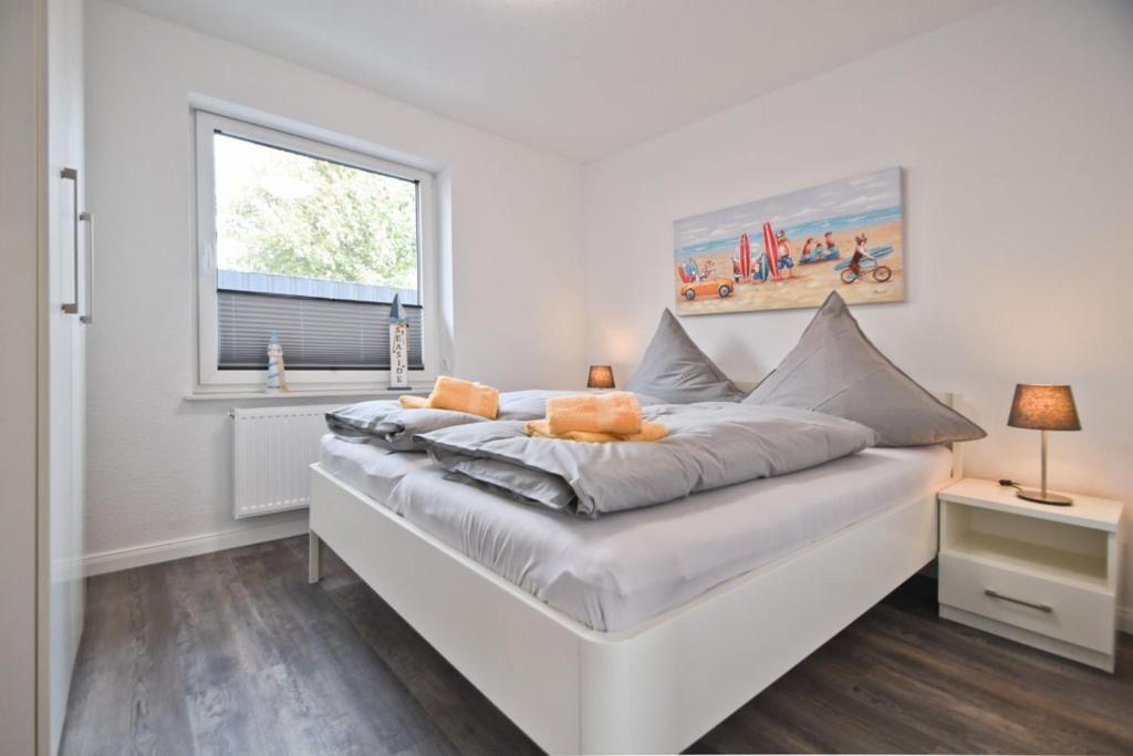 a white bed in a room with a window at Deichhöhe 7 HU in Norddeich