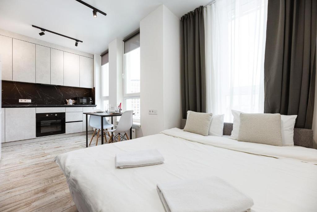 um quarto branco com 2 camas e uma cozinha em Nyvky Like Home - Нивки Парк - Студія 40-2 em Kiev
