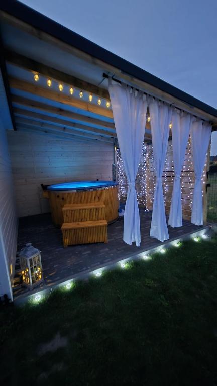 a deck with a pool table and some lights at Biały Sztorm in Rusinowo