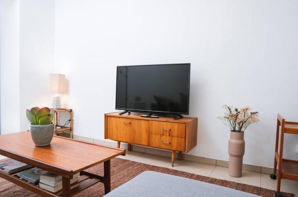 a living room with a flat screen tv on a wooden cabinet at Kaze - Bienvenue chez vous in Grimbergen