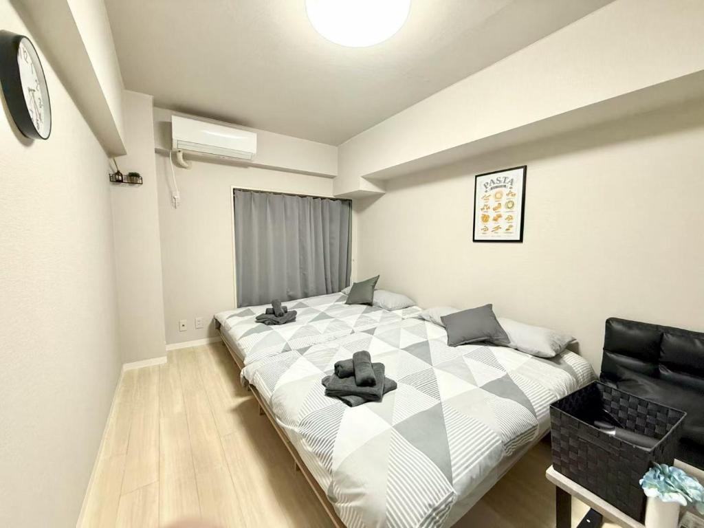 a bedroom with a large bed and a black chair at 池袋 Energy CA0 a9 in Tokyo
