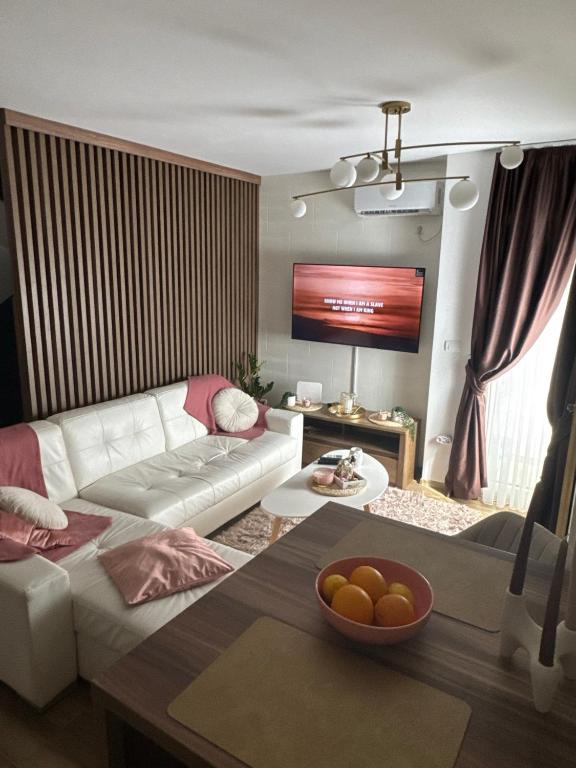 a living room with a white couch and a table at Freedom APARTMAN RUMA in Ruma